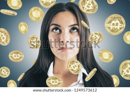 Thinking young businesswoman with bitcoin rain. Money and trade concept 