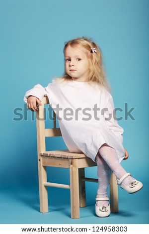 young girs sits on chair