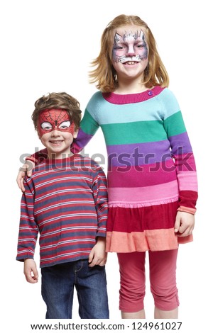 Young boy and girl with face painting of cat and spiderman smiling on white background
