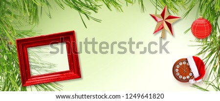 Red wooden frame with Christmas star, Santa Claus hat and clock on green background with Christmas tree branches