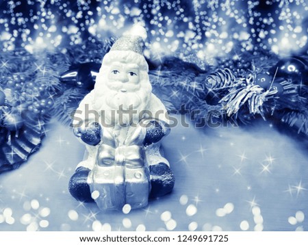 happy santa on branch of tree winter background with snow and snowflakes