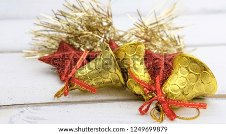 The items for decorating the Christmas tree such as a goal bells, a red stars and a bark. 