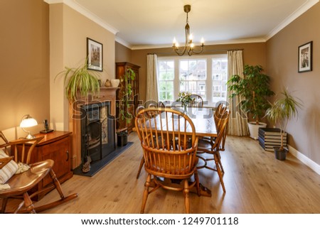 Traditional dining room interior with fireplace, wooden furniture, table and chairs