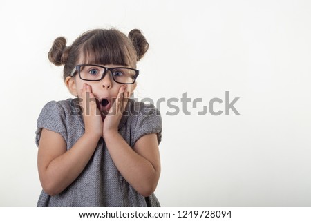 OMG! Wow! Happy surprised child 4-5 years old girl wearing eyeglasses, screaming with open mouth and crazy expression, isolated on white. Shocked face little kid girl on white background.  