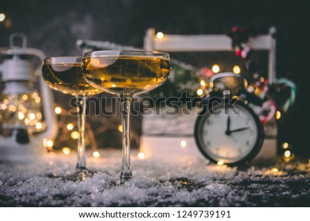 Image of two wine glasses on blurred background with Christmas tree, lantern, clock