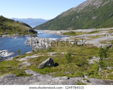 Beautiful waterfall of Norway with forest and river rocks