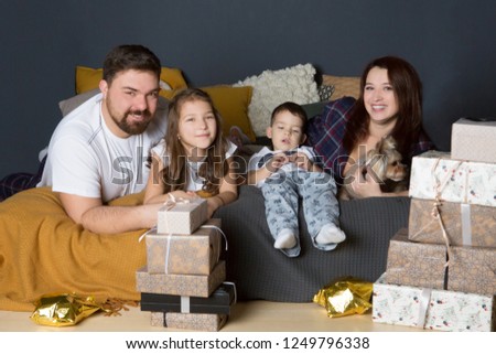 Portrait of friendly family with Christmas gifts on a bed at home. Christmas morning.