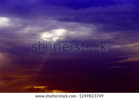 pictured in the photo through the clouds over the sea a ray of sunshine makes its way