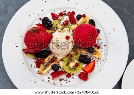 Banana split with vanilla and strawberry ice cream on a plate