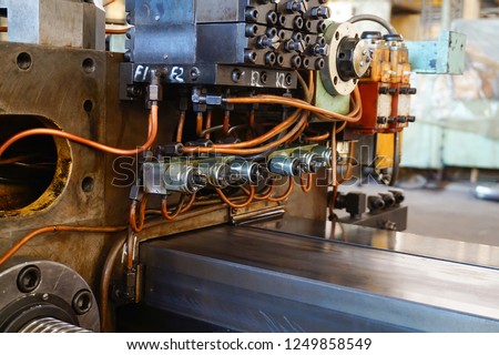 The hydraulic system on the machine, copper oil tubes connected to the equipment in production. Bed for guides under the influence of the hydraulic system. Abstract industrial background