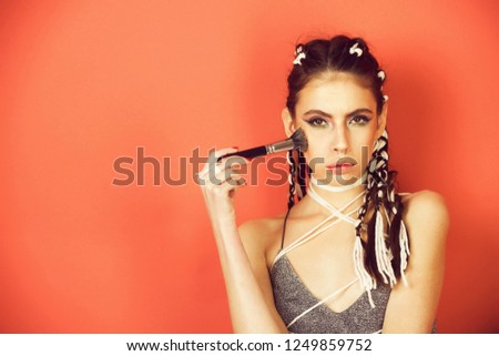 beauty, fashion photo of girl or woman with bright fashionable makeup on red background, copy space