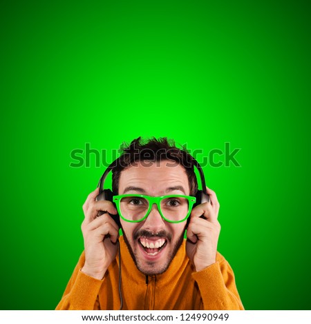 guy with headphones listening to music on green background