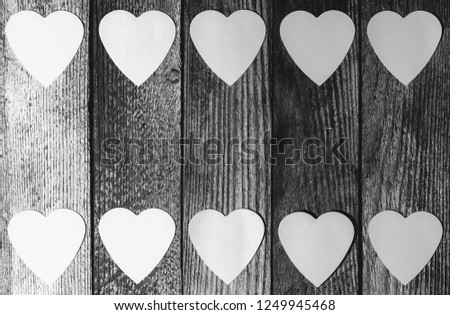 frame of paper hearts on wooden retro grunge background with copy space, top view flat lay, black and white photo