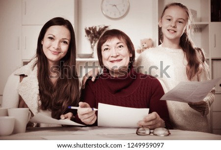 Three generations of happy family working together with documents at home