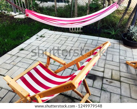 Outdoor in summer residence. Hammock and folding wooden chair.