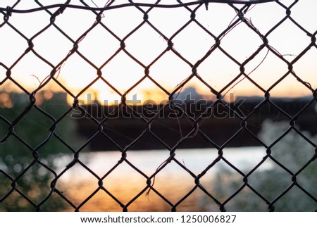 City at dusk through fence