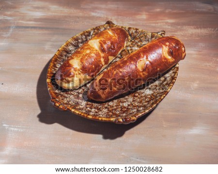 Two baguettes on a decorative plate in the shape of an owl on a brown background