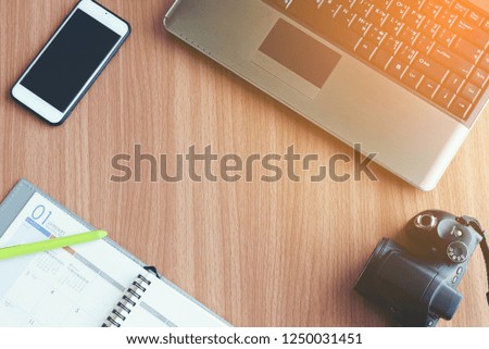 Top view flat lay laptop smart phone compact camera and pen on diary copy space wooden background concept