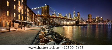Brooklyn Bridge Park waterfront in evening with view of skyscrapers of Lower Manhattan and the Brooklyn Bridge. Brooklyn, Manhattan, New York City