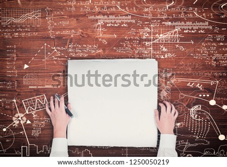 Top view of hands on blank paper on a wooden table drawn with a math formulas.