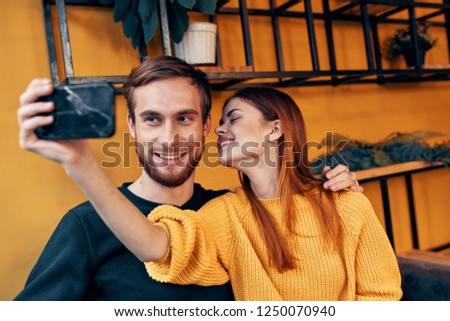 A man and a woman take pictures of themselves on the phone             