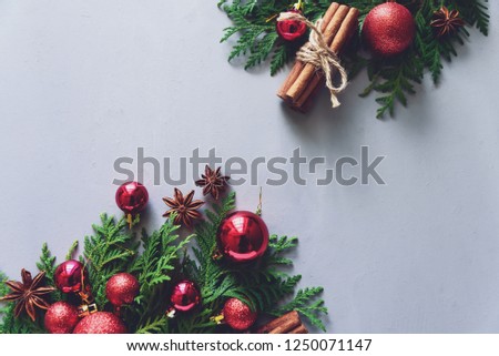 Christmas composition. Christmas fir tree branches, balls, cinnamon sticks and anise stars on gray wooden background. Flat lay. Top view. Copy space. Toned