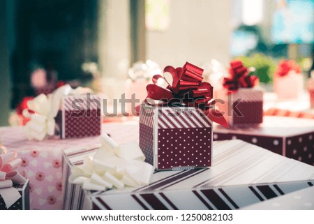Red and striped boxes with gifts tied bows in Christmas theme.