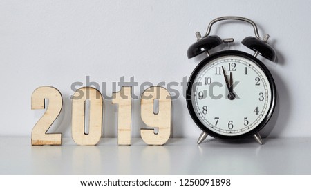 Happy New Year concept with alarm clock and wooden number 2019 on White Wall background, Copy space.
