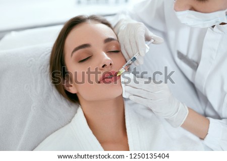 Lip Augmentation. Woman Getting Beauty Injection For Lips Royalty-Free Stock Photo #1250135404