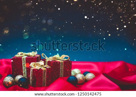 Sparkly red present boxes with Christmas lights on a red and blue background with bokeh