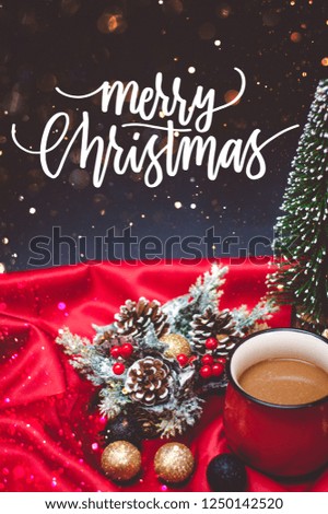 A coffee in a red cup with Christmas lights, bokeh and decoration with Merry Christmas quote