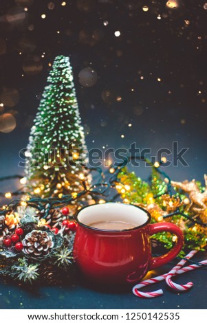 A coffee in a red cup with Christmas lights, bokeh and decoration