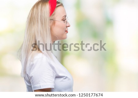 Young blonde woman wearing glasses over isolated background looking to side, relax profile pose with natural face with confident smile.