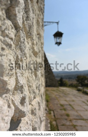 wall of an old building and a lantern against the blue sky

