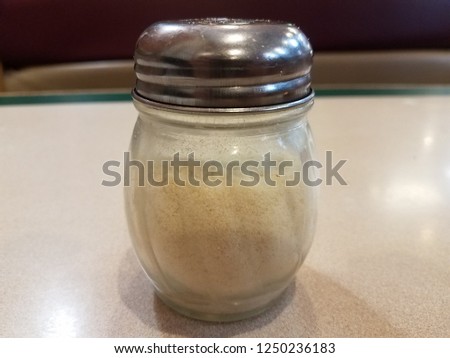 a glass parmesan cheese shaker for pizza