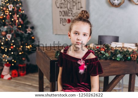 Christmas new year portrait of happy young teen girl with curly hair in cozy home with holiday decorations