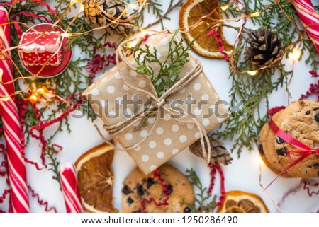 gift box on table with cookies, candies and lights. dry orange slices, candles.