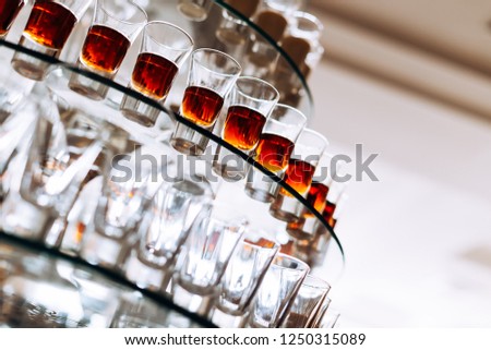 A close-up of alcohol glasses on a transparent tiered stand