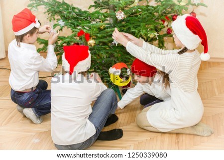  boys and girl decorate christmas tree