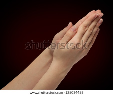 girls hands folded in prayer isolated on black