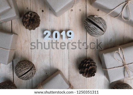 Happy new year 2019 background concept from top view, gift and pine cone decoration on vintage wooden background, copy space