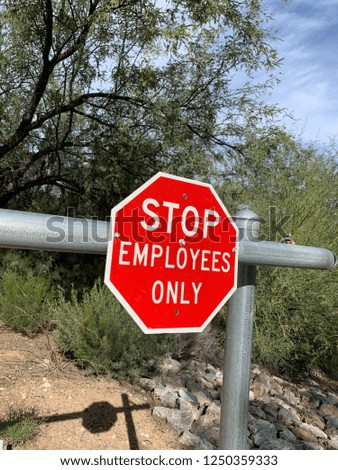 Stop Employees Only sign on metal fence in desert