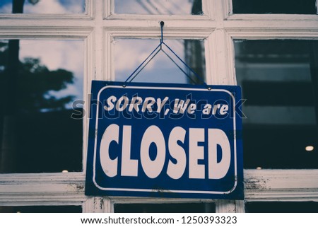 A Sign board of sorry we are closed hang on door of business shop with nature green background