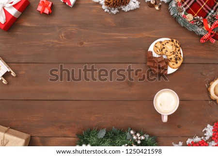 New year theme plate of cookies and milk chocolate cubes cup of hot coffee isolated on decorated wooden table top view close-up copy space