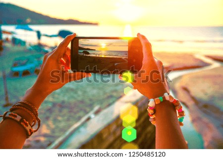 Asian woman travel nature. Travel relax. Use cell phone take pictures the sunset on the beach. In the summer