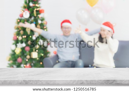 Empty white marble stone table top on blur with bokeh Christmas tree background with people in holiday party - can be used for display or montage your products.