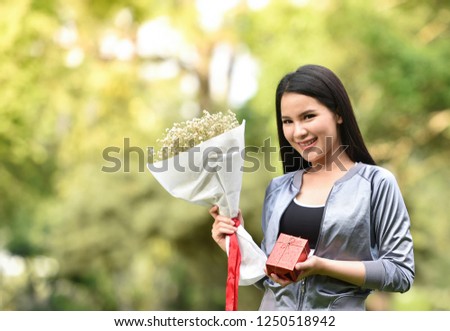 woman hold flower bouquet / gift box and bouquet flower in hand beautiful girl sport outdoors - flowers for gift new year on nature green background 