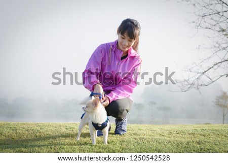 Beautiful smiling woman and her dog in the garden.