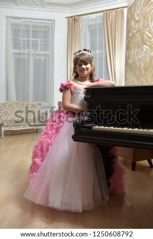 The young princess in white with a pink dress with a piano