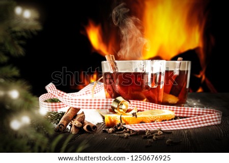 Winter time and fresh hot mulled on table. Fireplace background and christmas tree. 